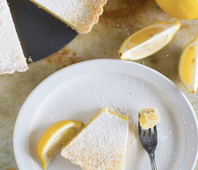 Готовый лимонный пирог посыпьте сахарной пудрой