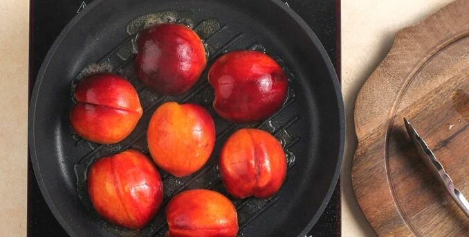 Переверните персики и посыпьте в местах разреза смесью коричневого сахара и специй.