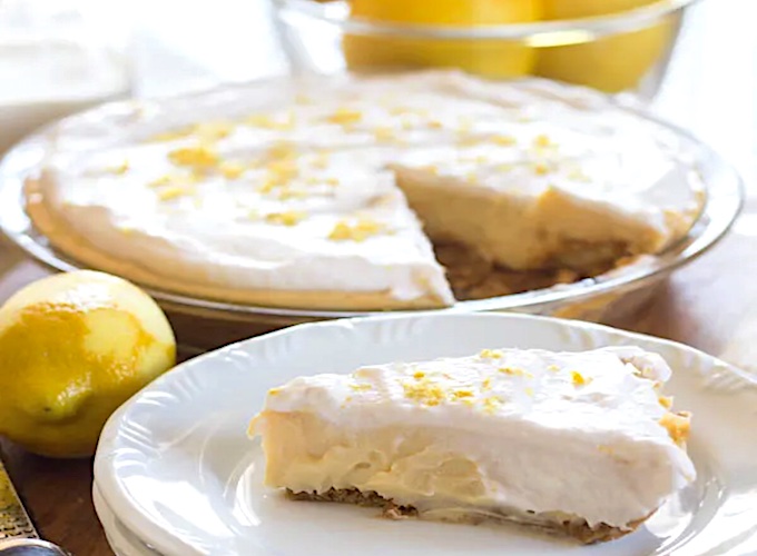 Перед подачей украсьте лимонный пирог взбитыми сливками и мелконатертой цедрой свежего лимона. 